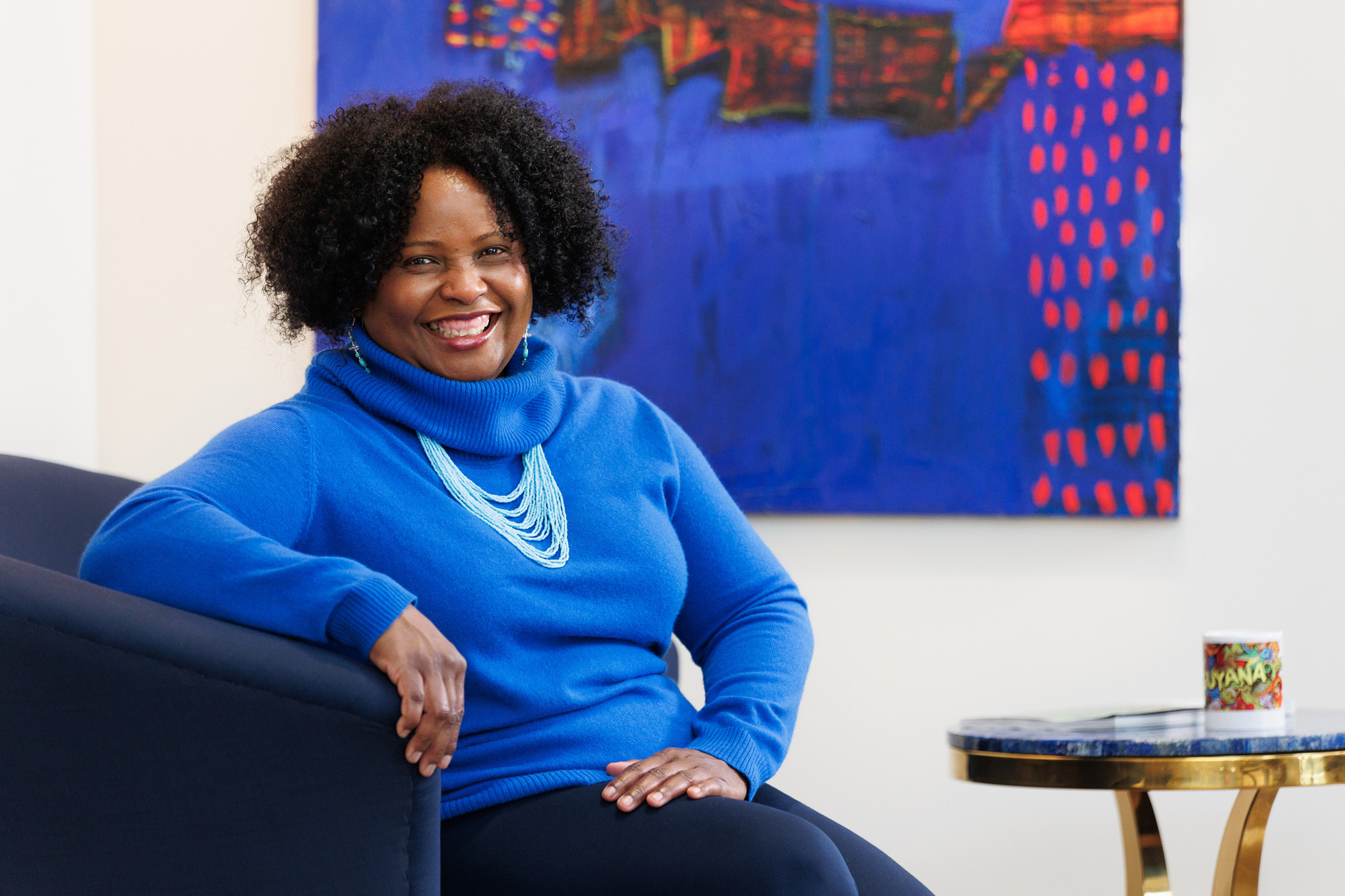 Mahalia Arjoon-Purchase, warm portrait with Guyana mug